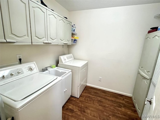 clothes washing area with cabinet space, washing machine and clothes dryer, dark wood-style floors, and baseboards