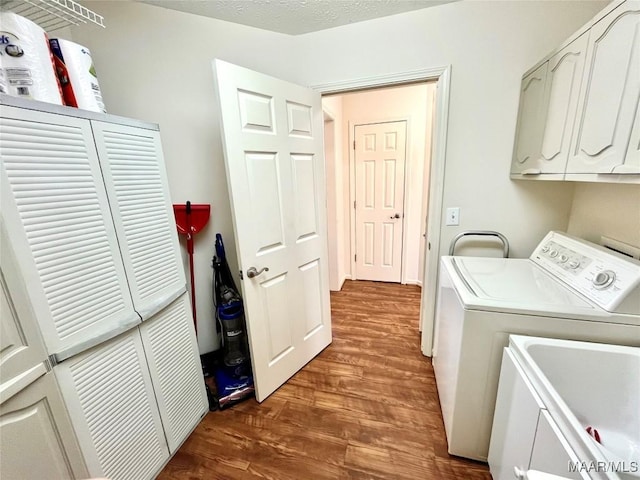clothes washing area featuring cabinet space, dark wood-style flooring, and separate washer and dryer
