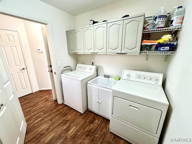 washroom featuring independent washer and dryer, dark wood-style floors, cabinet space, and a textured ceiling