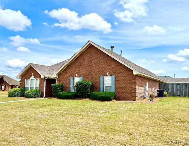 view of property exterior with brick siding, a yard, central AC, and a shingled roof