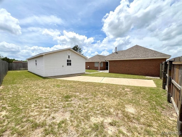 back of house with brick siding, a patio, and roof with shingles