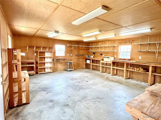 miscellaneous room featuring a workshop area and unfinished concrete floors