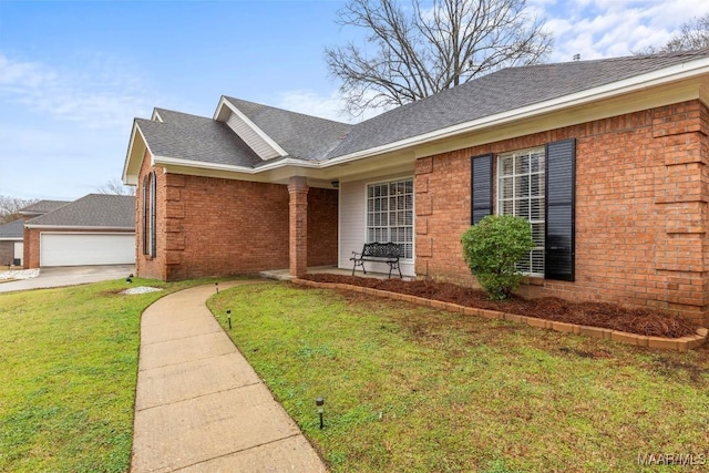 single story home with a garage, brick siding, roof with shingles, and a front yard