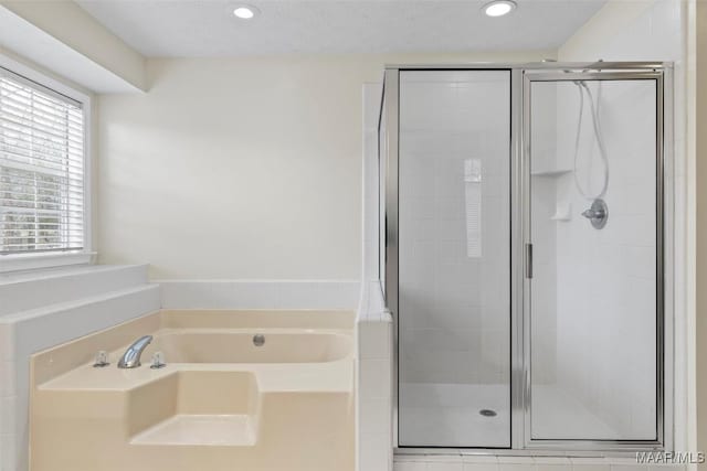 bathroom with a bath, recessed lighting, and a stall shower