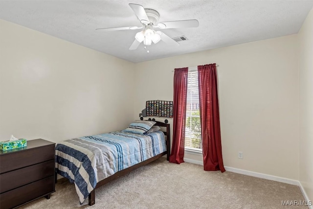 carpeted bedroom with visible vents, multiple windows, baseboards, and a ceiling fan