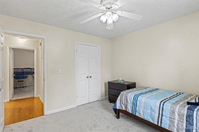 bedroom with baseboards, carpet floors, a closet, and ceiling fan