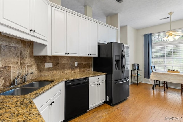 kitchen featuring a sink, tasteful backsplash, black dishwasher, light wood-style floors, and stainless steel fridge with ice dispenser