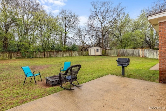 view of patio with an outbuilding, a fire pit, a storage shed, and a fenced backyard