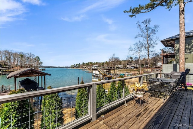 wooden deck featuring a boat dock and a water view