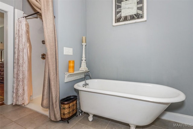 full bathroom featuring tile patterned floors, a freestanding tub, and a shower with curtain