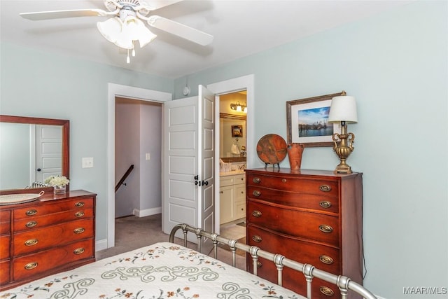 carpeted bedroom featuring baseboards, ensuite bathroom, and ceiling fan