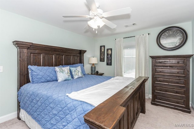 bedroom featuring visible vents, light carpet, baseboards, and a ceiling fan