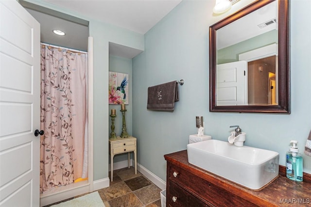 bathroom with visible vents, curtained shower, vanity, and baseboards