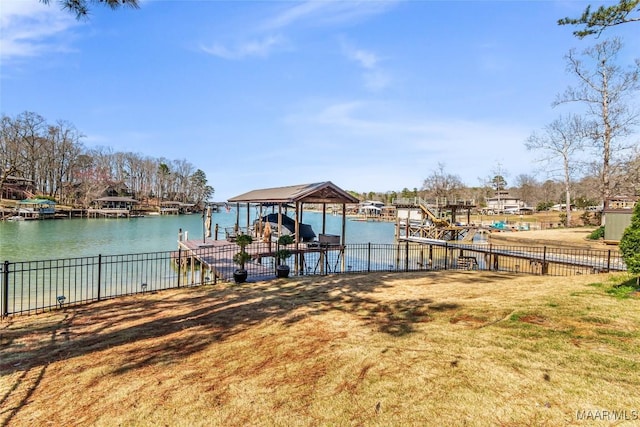 dock area featuring a water view, boat lift, and fence