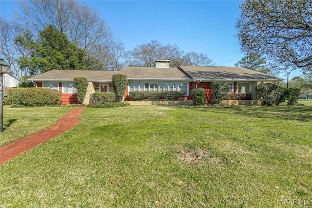 ranch-style home with a chimney and a front yard