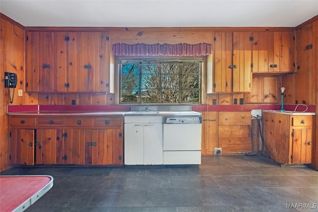 kitchen featuring brown cabinetry, dishwasher, light countertops, and a sink