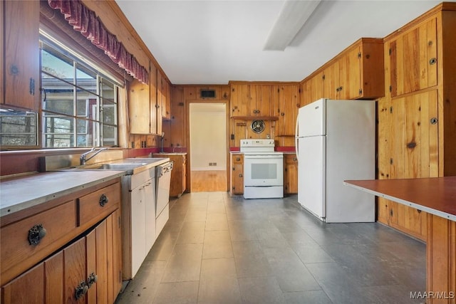 kitchen featuring white appliances, visible vents, a sink, light countertops, and brown cabinets