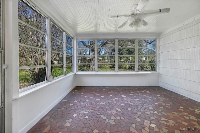 unfurnished sunroom with a ceiling fan