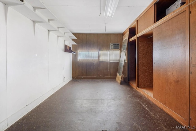 spare room with an AC wall unit and wood walls