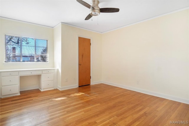 unfurnished bedroom featuring ornamental molding, a ceiling fan, light wood finished floors, baseboards, and built in study area