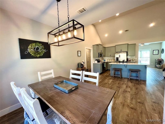 dining room featuring ceiling fan, visible vents, and dark wood-style floors