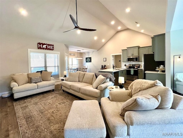 living area featuring dark wood-style floors, visible vents, high vaulted ceiling, and ceiling fan