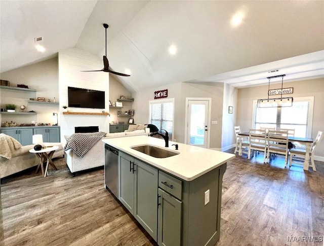 kitchen featuring gray cabinetry, a sink, stainless steel dishwasher, dark wood-style floors, and open floor plan