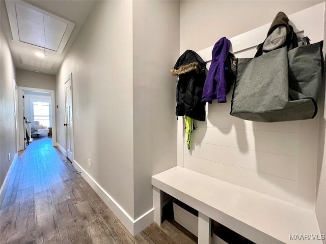 mudroom featuring attic access, wood finished floors, and baseboards