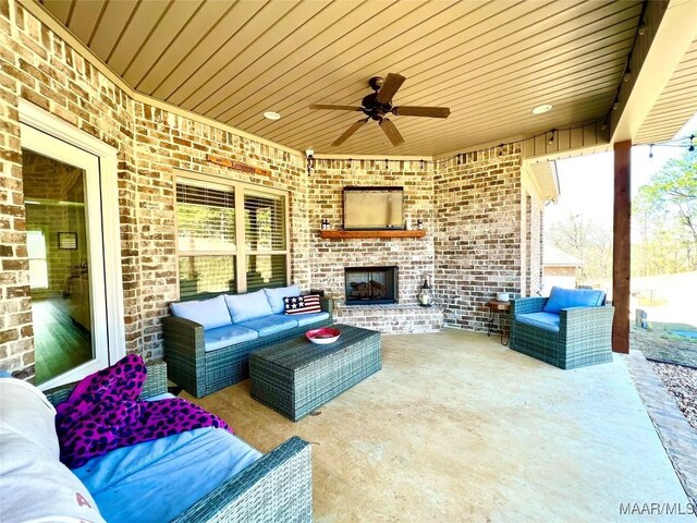 view of patio with ceiling fan and an outdoor living space with a fireplace