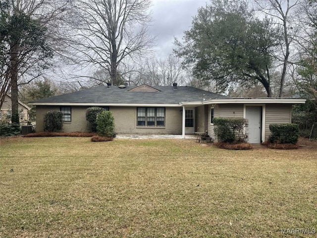 view of front facade with brick siding, cooling unit, and a front yard