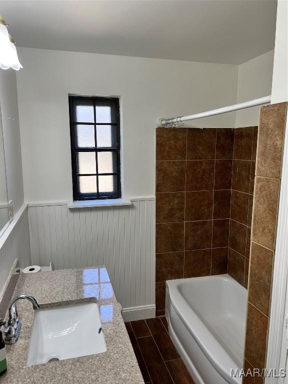 bathroom with wood tiled floor, wainscoting, and a sink