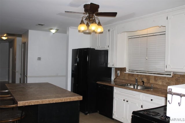 kitchen with dark countertops, decorative backsplash, white cabinets, and black appliances