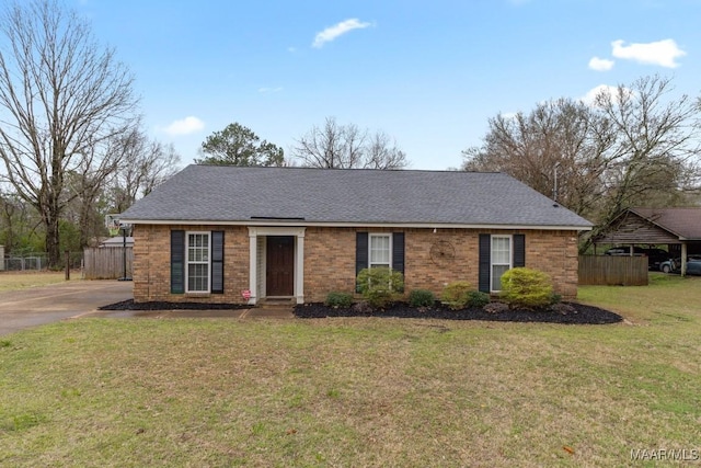 single story home featuring brick siding, a shingled roof, a front lawn, and fence