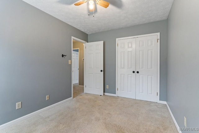 unfurnished bedroom featuring a closet, baseboards, carpet floors, and a textured ceiling