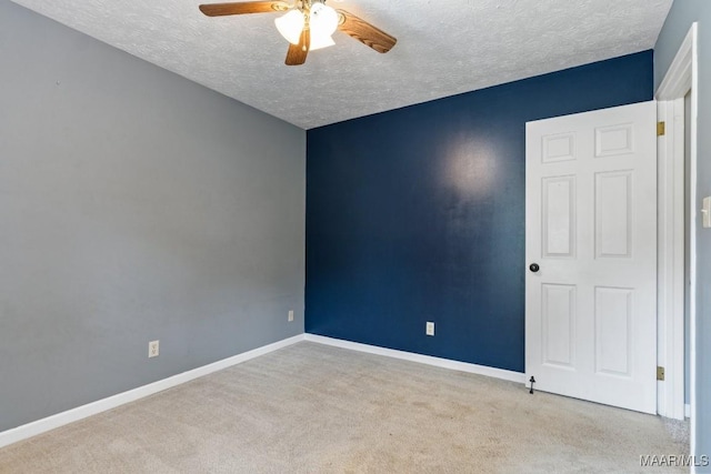 empty room with baseboards, a textured ceiling, a ceiling fan, and carpet