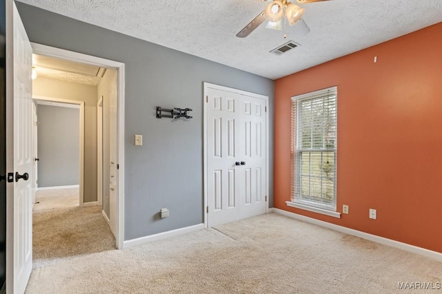 unfurnished bedroom with carpet flooring, baseboards, visible vents, and a textured ceiling