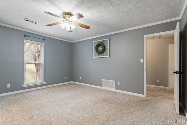 spare room with crown molding, carpet flooring, and visible vents