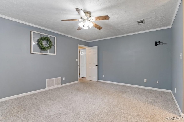 carpeted empty room featuring visible vents, a textured ceiling, and crown molding