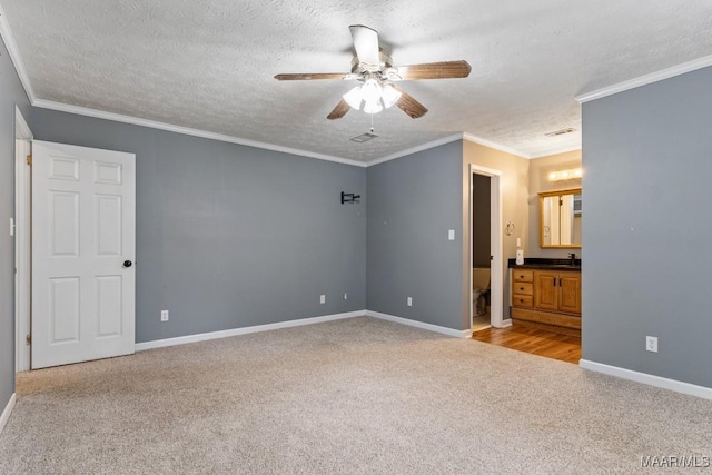 unfurnished bedroom featuring ornamental molding, a textured ceiling, baseboards, and carpet floors