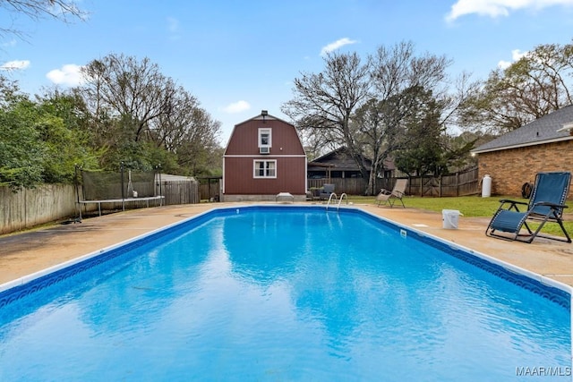 view of pool featuring a fenced in pool, a trampoline, a fenced backyard, an outdoor structure, and a patio area