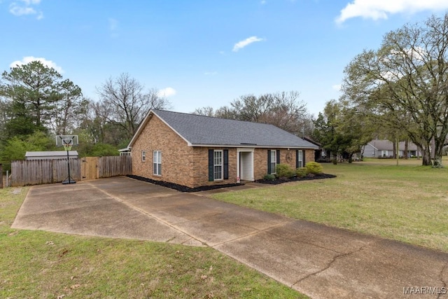 view of front of home featuring a front lawn, fence, brick siding, and roof with shingles