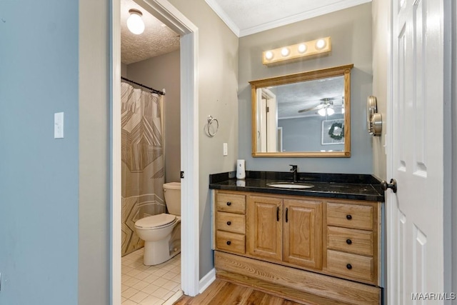 bathroom featuring vanity, ornamental molding, toilet, and a textured ceiling