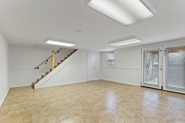 interior space with a wainscoted wall and stairs