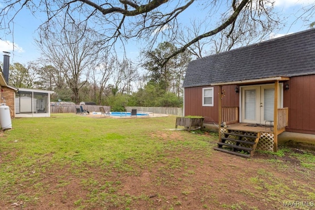 view of yard featuring a fenced in pool, a sunroom, french doors, and fence