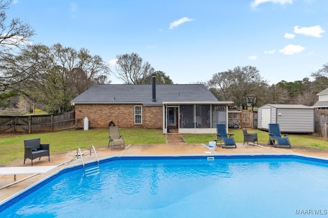 view of pool with a yard, a fenced backyard, a shed, and a sunroom