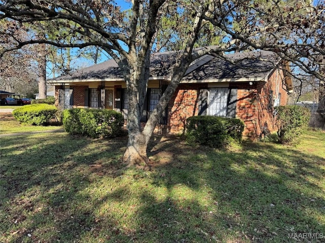 view of front of house featuring brick siding and a front lawn