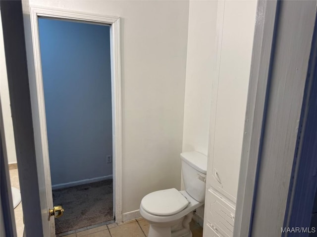 bathroom with tile patterned flooring, toilet, and baseboards