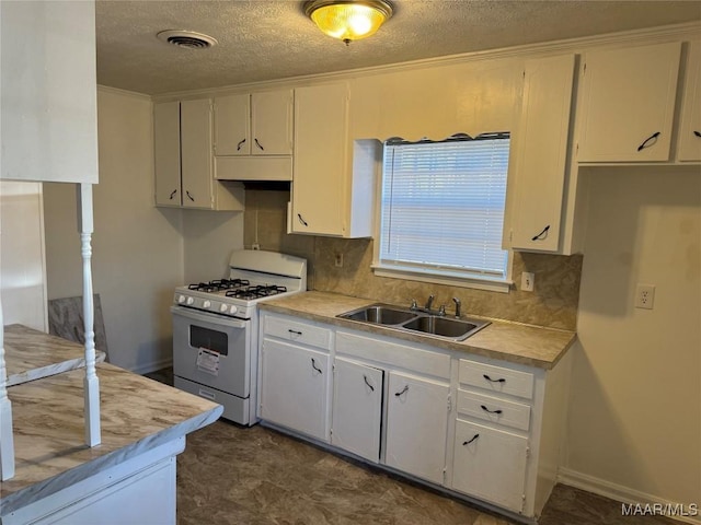 kitchen featuring visible vents, light countertops, white gas range oven, white cabinetry, and a sink