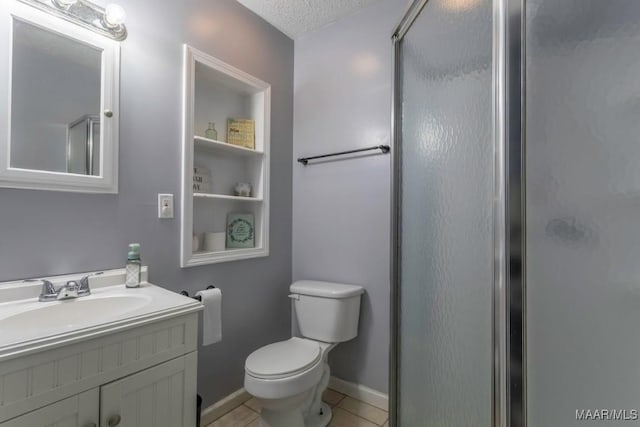 bathroom featuring tile patterned flooring, toilet, a stall shower, a textured ceiling, and vanity