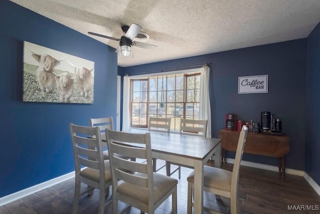 dining space featuring a ceiling fan, wood finished floors, baseboards, and a textured ceiling